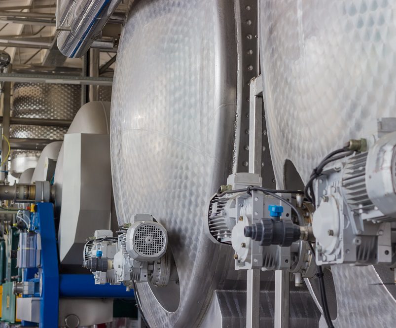 Stainless steel vessels and other equipment in workshop of primary grapes processing and primary fermentation in the modern winery